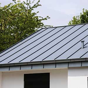 Close up of a home with a light gray standing seam metal roofing system
